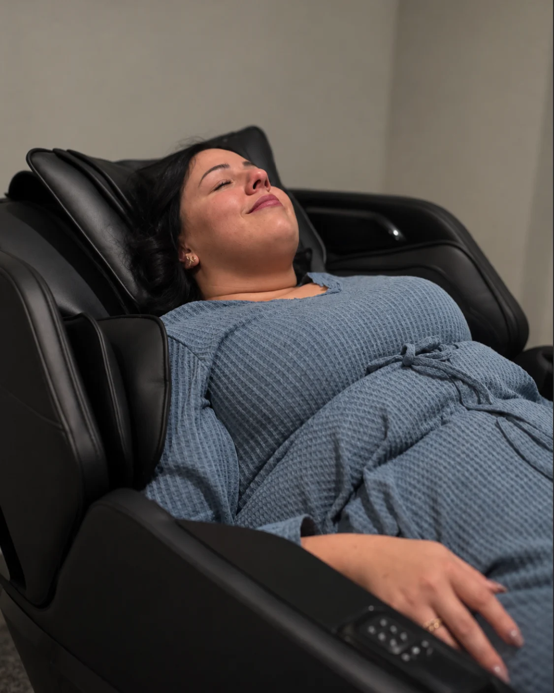 Woman relaxing in a zero gravity massage chair at Body Ache Escape